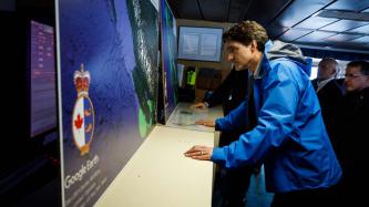 PM Trudeau looks at a satellite map