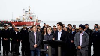 PM Trudeau listens to a Coast Guard member