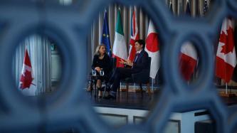 PM Trudeau sits on stage with the moderator