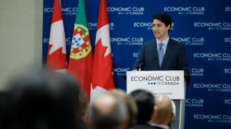 Prime Minister Justin Trudeau stands in front of a podium with a sign that reads Economic Club of Canada