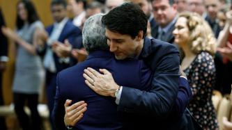 Prime Minister Justin Trudeau hugs the Prime Minister of Portugal, António Costa, while others stand and clap