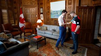 Prime Minister Justin Trudeau stands and meets with Canadian Olympic gold medalist Brady Leman in his office and examines his gold medal