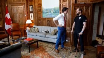 Prime Minister Justin Trudeau stands and speaks with Canadian Paralympian gold medalist Kurt Oatway in his office