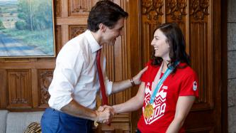 Prime Minister Justin Trudeau stands and shakes hands with Canadian Olympic gold medalist Kelsey Serwa in his office