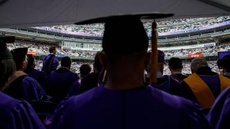 Prime Minister Justin Trudeau addresses a crowd of graduates from a podium in Yankee Stadium