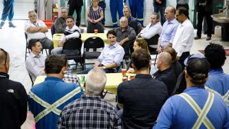 Prime Minister Trudeau sits and talks with employees.