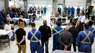 Prime Minister Trudeau sits and talks with employees.