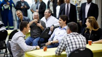 Prime Minister Trudeau sits and talks with employees.