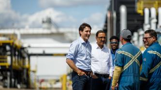 Prime Minister Trudeau talks with workers outside.