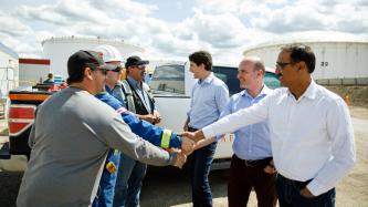 MP Randy Boissonault and Minister Sohi shakes hands with workers outside.
