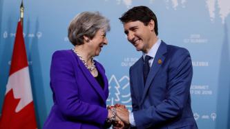 Le PM Justin Trudeau serre la main de la PM Theresa May.