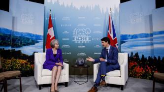 Le PM Trudeau s'assoit et discute avec la PM Theresa May.