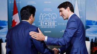Le premier ministre Trudeau serre la main du PM Shinzo Abe.
