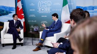 Le PM Trudeau s'assoit et discute avec le PM Giuseppe Conte.