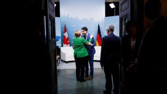 Le PM Trudeau fait une caresse à la chancelière Angela Merkel.