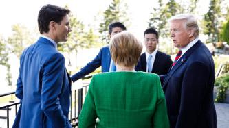 PM Justin Trudeau talks with G7 leaders on a deck.