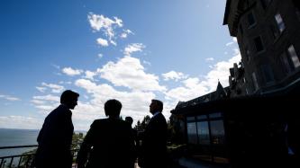 PM Justin Trudeau talks with G7 leaders on a deck.