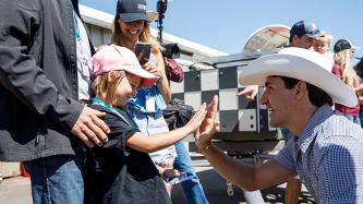Prime Minister Justin Trudeau high-fives a young girl at the Calgary Stampede.