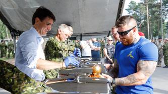 Le PM Trudeau sert un repas à un militaire