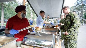 Le PM Trudeau et le ministre Sajjan servent un repas à des militaires