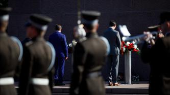 Le premier ministre Trudeau se tient debout devant le Monument de la liberté