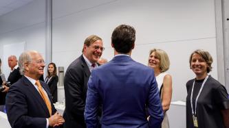 Prime Minister Trudeau talks with people in a room.