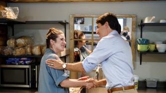 PM Trudeau shakes hands with a woman in the kitchen of a bakery