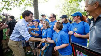 PM Trudeau shakes hands with a woman