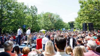 PM Trudeau and MP Sean Fraser stand on a platform among a crowd