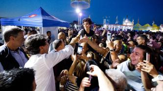 PM Trudeau greets people in a large outdoor crowd