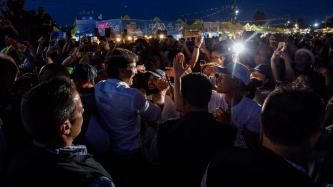 PM Trudeau greets people in a large outdoor crowd