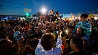PM Trudeau greets people in a large outdoor crowd