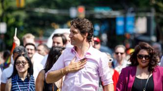 PM Trudeau walks and holds his hand to his chest