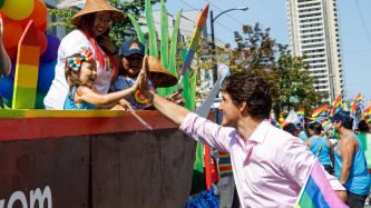 PM Trudeau high fives a little girl in a Pride Parade