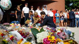 Le PM Trudeau, Hadrien et le député Matt DeCourcey déposent des fleurs au monument