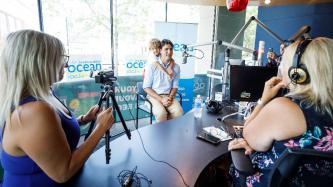 PM Trudeau speaks into a microphone at the Ocean 100 radio station