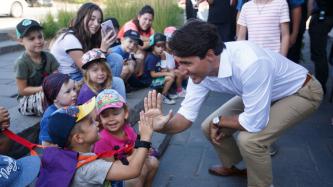PM Trudeau high fives a young boy