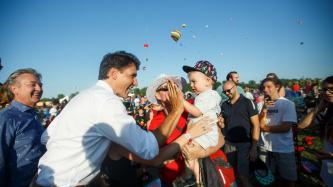 PM Trudeau high fives a young boy