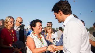 PM Trudeau shakes hands with a woman