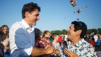 PM Trudeau shakes hands with a woman