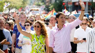 PM Trudeau and Sophie smile and wave to the crowd