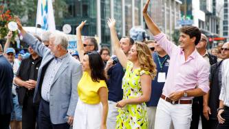 PM Trudeau and Sophie smile and wave to the crowd
