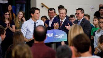 L’auditoire applaudit le PM Trudeau, qui parle au lutrin