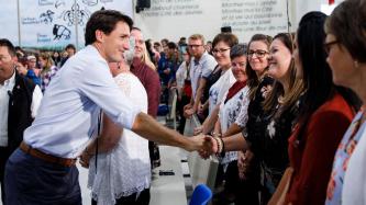 Le PM Trudeau serre la main d’une femme dans l’auditoire