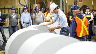 PM Trudeau touches a large roll of paper