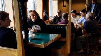 PM Trudeau sits with a group of men at a booth in the restaurant