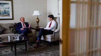 PM Trudeau sits and listens to MP Boissonnault in an office