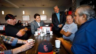 PM Trudeau sits with a group of men at the restaurant
