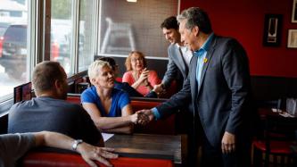 MP Vandal and PM Trudeau shake hands with two women