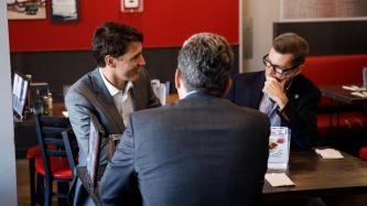 PM Trudeau sits and speaks with MPs Vandal and Eyolfson